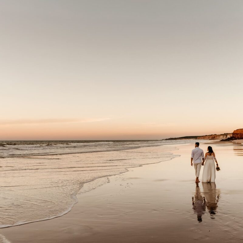 honeymoon planning couple walking on beach